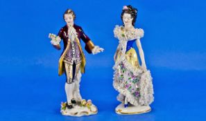 Matched Pair of Dresden Figures in 18th century style dress, with lace trim, the lady on a heart
