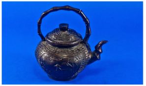 A Small Lidded Bronze Teapot with a wicker design to the body with two cartouches of fishermen in