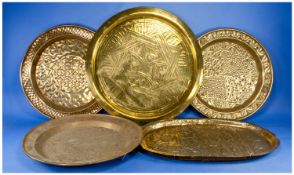 Five Middle Eastern Brass Plaques, three with ethnic geometric embossed designs. One with Islamic