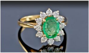 18ct Gold Emerald & Diamond Cluster Ring. The oval emerald surrounded by 13 diamonds. The emerald