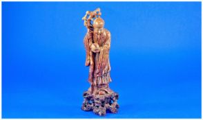 Mottled Brown Chinese Soapstone Figure, well carved. Depicting a Sage Holding a peach and knarrled