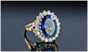 A 9ct Gold Set Blueberry and Diamond Cluster Ring. The oval blueberry stone surrounded by 22 small