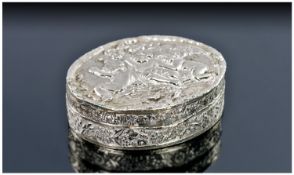 A Continental Silver Snuff Box. Oval shape with a hinged lid embossed with three cherubs amongst