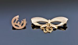 A 9ct Gold Ribbon Brooch. Stamped 9ct. 1 1/4 inches in length, plus a 9ct gold small brooch. Total