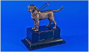 A Fine Silvered Figure of a Labordor Guide Dog for the Blind. Raised on a black wooden plinth. 7