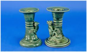 Pair of Teal Coloured Squat Candlesticks of turned form surmounted by ape figures. 4.5 inches high.