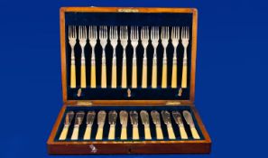 An Oak Fitted Cased Set of EPNS Fish Knives and Forks (24 pieces), bone type handles. c 1920`s.