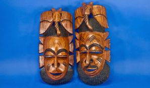 Pair of African Carved Hardwood Wall Masks, modern, each measuring 15 inches high.