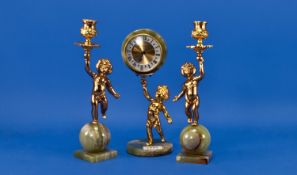 Three Piece French Style Ormolu and Onyx Clock Set with two cherubs holding up a cherub holding a