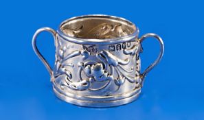 An Edwardian Art Nouveau Miniature Twin Handled Silver Cup. The exterior in bold relief with