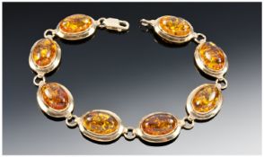 9ct Gold set Natural Amber bracelet. The bracelet consists of 8 sections of oval cut natural amber