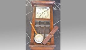 Early 20th Century Oak Cased Wall Clock, silvered dial, Arabic numerals, glazed door with bevelled