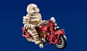 Cast Iron Novelty Money Bank in the Form of the Michelin Man riding a motor bike.