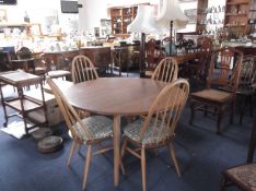 Ercol Elm Topped Dining Table and Four Chairs, the table raised on beech legs, the chairs with elm