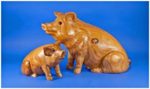 Two Carved Wooden Pig Figures with glass eyes. 13 and 8 inches in height.