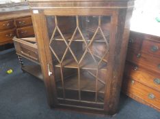 Early 20th Century Oak Corner Unit, over hanging cornice, glazed door, fitted with shelves, raised