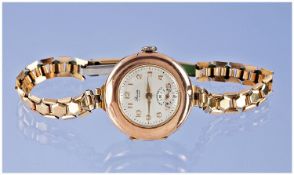 Ladies 9ct gold wrist watch supported on a gold plated bracelet. Working order hallmark London