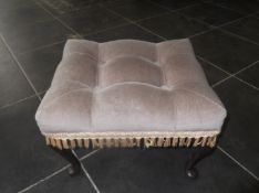 Footstool, beige upholstered fabric and tasseled fringe.