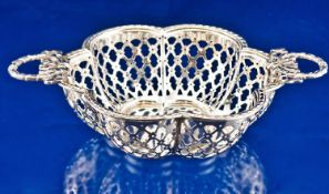 A silver fine two handle bonbon dish with openwork shaped sides and garland and ribbon handles.