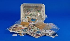 Margarine tub full of many thousands of all world stamp, mostly off paper.  Many in packets with