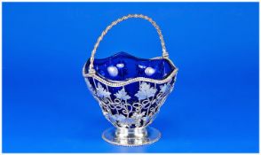 A silver swing handled basket of circular form with original blue glass liner. The body