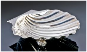 A Heavy Quality Silver Butter Dish, realistically executed as a scallop shell on two whelk feet.