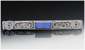 Silver Rectangular Bar Brooch Central Blue Faceted Stone Set Between A Wirework Design. Length 62mm