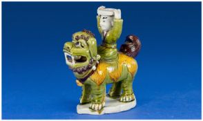 A Chinese Biscuit Porcelain Figure of a Lion Dog and Rider in a Sancai - type glaze. 19th Century