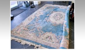 Large Sized Oriental Woolen Rug, with a symmetrical floral pattern on a pale blue ground, fringe