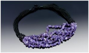 Amethyst Six Strand Necklace on multiple black silk cords with a button and loop fastening; 18