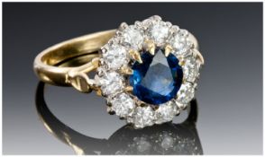18ct Gold Diamond & Sapphire Ring Set With A Central Medium Blue Sapphire Surrounded By 10 Round