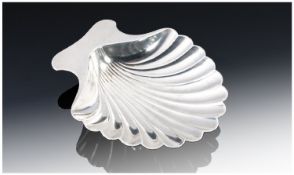 Tiffany and Co. A Sterling Silver Butter Dish,. Scallop shaped and supported on two ball feet.