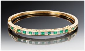 18ct Gold Diamond And Emerald Bangle, The Front Set With 24 Alternating Baguette Cut Diamonds And
