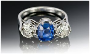 A Vintage Platinum Set 3 Stone Diamond and Sapphire Ring. The central blue sapphire flanked by 2