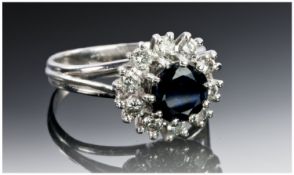 18ct White Gold Diamond & Sapphire Ring Set With A Central Dark Blue Sapphire Surrounded By 10