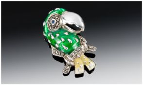 An Amusing Silver Enamel & Marcasite Brooch of a parrot perched on a branch. The main body in