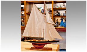 Small Model of a 20th Century Yacht, with linen sails, complete with stand, measuring 35 inches