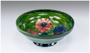 William Moorcroft Signed Footed Inverted Bowl, `Anemone` pattern on emerald green ground. 6.75`` in