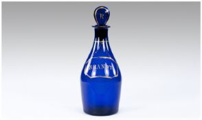 Small Bristol Blue Brandy Decanter, the blue bottle shaped body having a painted gilt label reading