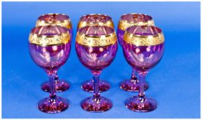 Set of Six Italian Ruby Coloured Drinking Glasses, with gilt decoration to rims, raised on stems.