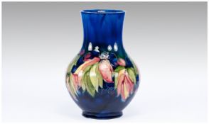 Moorcroft Leaves and Berries Pattern Vase, baluster shape, the polychrome pattern on a deep blue