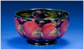 William Moorcroft Footed Bowl `Pomegranate` Design on blue ground. c 1920. 3.5 inches high and 6.25