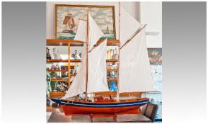 Large Model of an Early 20th Century Yacht, raised on a wooden plinth, with linen sails, propeller