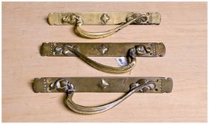 Three Art Nouveau Brass Handles, with curving handles, measuring approximately 14 inches high.