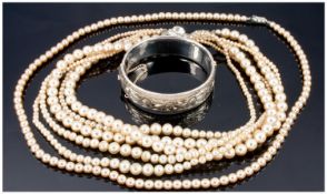 Broad Silver Hinged Bangle Together With Three Strands Of Simulated Pearl Necklaces.