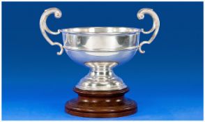 Edwardian Silver Two Scroll Handle Trophy Shaped Bowl. Supported on a circular and stepped wooden