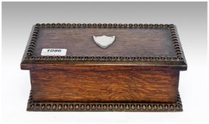 Early 20th Century Oak Lidded Box, the top with a vacant shield shaped cartouche to centre, the