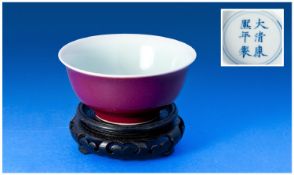 A Chinese Porcelain bowl, the exterior in deep aubergine glaze. To the base a six character Qing