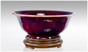 A Large Chinese Sang-de-Boeuf Porcelain Bowl with everted rim and cafe-au-lait base. With Hardwood