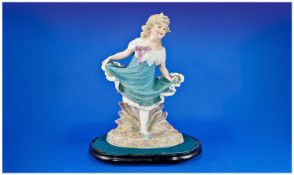 Large Heubach Bisque Figure of a Dancing Girl, holding out the hem of her textured turquoise dress
